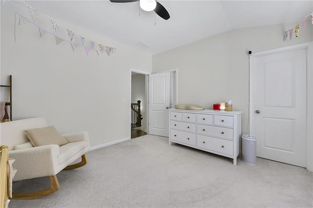 sitting room with baseboards, ceiling fan, light colored carpet, vaulted ceiling, and an upstairs landing