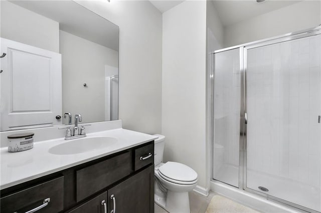 full bathroom featuring vanity, a shower stall, and toilet
