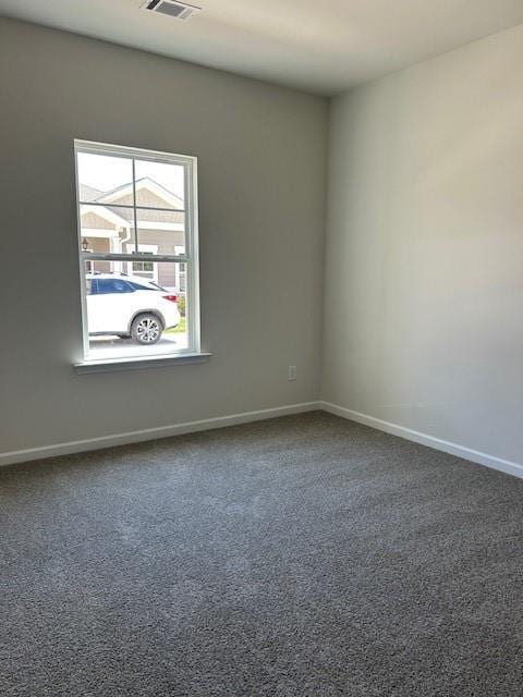 carpeted spare room featuring baseboards