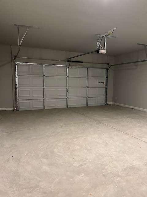 garage with a garage door opener and baseboards