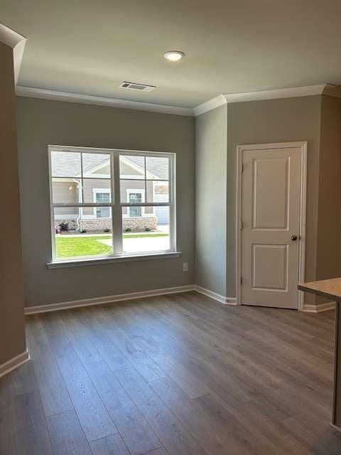 unfurnished room with crown molding, wood finished floors, baseboards, and recessed lighting