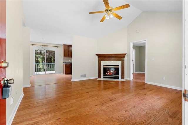 6752 Stringer Rd, Clermont, GA 30527 - unfurnished living room featuring a ceiling fan, light wood-style flooring, a fireplace, high vaulted ceiling, and baseboards