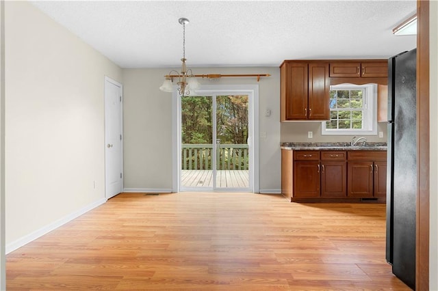 6752 Stringer Rd, Clermont, GA 30527 - kitchen with a chandelier, freestanding refrigerator, light wood-style flooring, hanging light fixtures, and baseboards