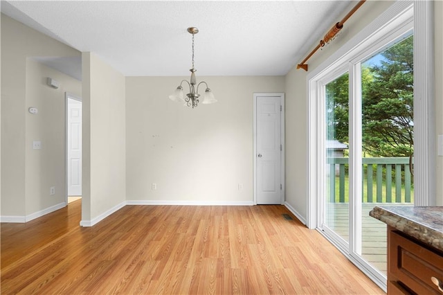 6752 Stringer Rd, Clermont, GA 30527 - unfurnished dining area with a chandelier, light wood-style floors, and baseboards