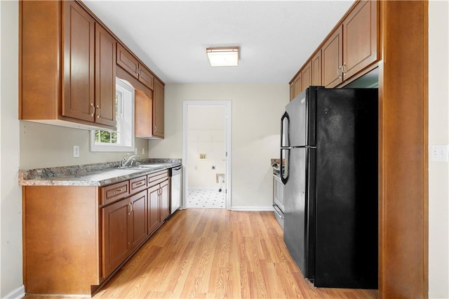 6752 Stringer Rd, Clermont, GA 30527 - kitchen with stainless steel appliances, light wood-style flooring, a sink, light countertops, and brown cabinets