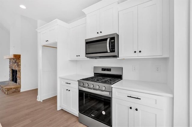 19 Bridgemill Dr, Douglasville, GA 30134 - kitchen with stainless steel appliances, light countertops, light wood-type flooring, white cabinets, and recessed lighting