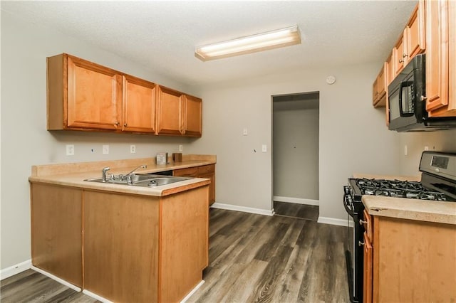 155 Oak Terrace Dr, Covington, GA 30016 - kitchen featuring stainless steel range with gas stovetop, black microwave, a peninsula, dark wood-style floors, and light countertops