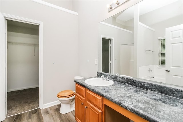 155 Oak Terrace Dr, Covington, GA 30016 - full bath featuring wood finished floors, vanity, a bath, toilet, and a walk in closet
