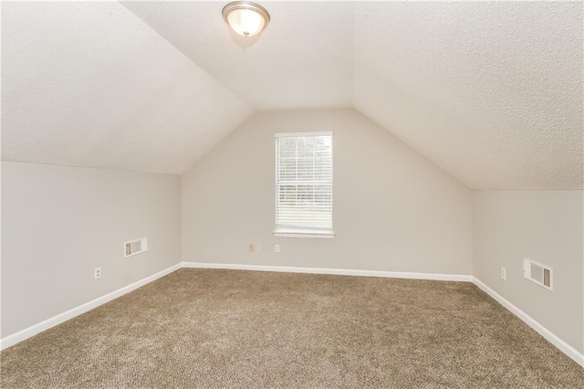 155 Oak Terrace Dr, Covington, GA 30016 - additional living space featuring a textured ceiling, carpet, vaulted ceiling, and baseboards