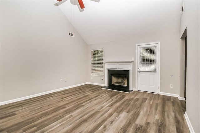 155 Oak Terrace Dr, Covington, GA 30016 - unfurnished living room featuring ceiling fan, wood finished floors, a fireplace with raised hearth, baseboards, and high vaulted ceiling