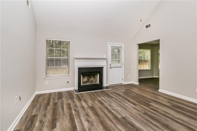 155 Oak Terrace Dr, Covington, GA 30016 - unfurnished living room featuring a fireplace with raised hearth, wood finished floors, baseboards, and high vaulted ceiling