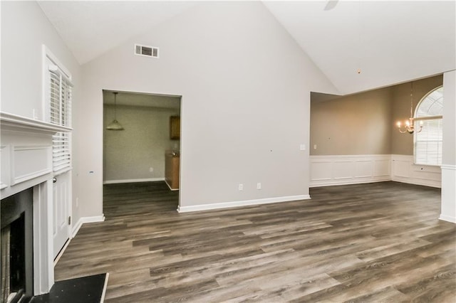 155 Oak Terrace Dr, Covington, GA 30016 - unfurnished living room featuring a high end fireplace, a chandelier, high vaulted ceiling, wood finished floors, and a wainscoted wall