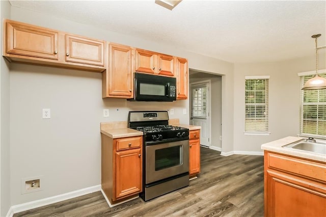 155 Oak Terrace Dr, Covington, GA 30016 - kitchen featuring stainless steel range with gas cooktop, black microwave, dark wood-style flooring, light countertops, and baseboards