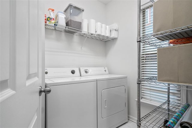 laundry area with light tile patterned floors and washing machine and clothes dryer