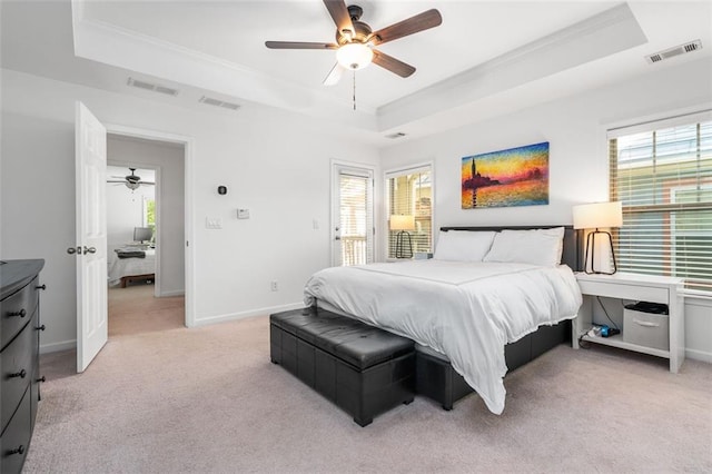 bedroom with multiple windows, a tray ceiling, and ceiling fan