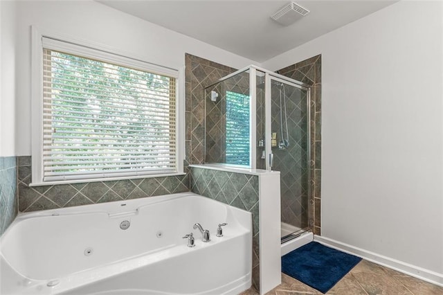 bathroom featuring independent shower and bath, a healthy amount of sunlight, and tile patterned floors