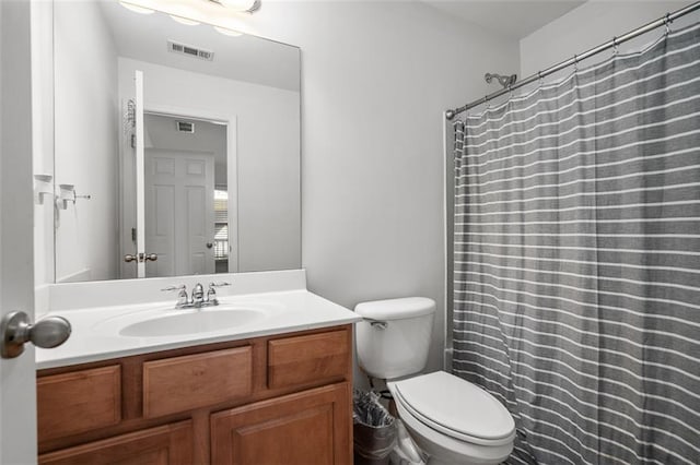 bathroom featuring toilet, walk in shower, and vanity