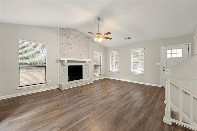 unfurnished living room featuring a fireplace, dark hardwood / wood-style flooring, lofted ceiling, and ceiling fan