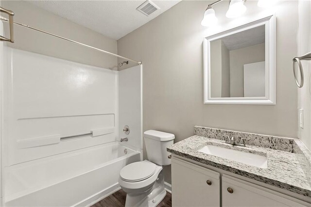 full bathroom featuring hardwood / wood-style floors, vanity, toilet, and bathing tub / shower combination