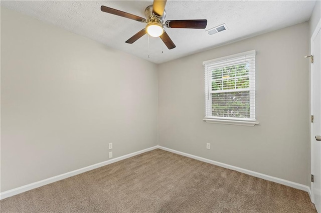 empty room with carpet flooring, a textured ceiling, and ceiling fan