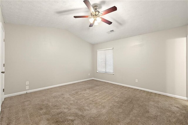 carpeted spare room featuring vaulted ceiling, ceiling fan, and a textured ceiling