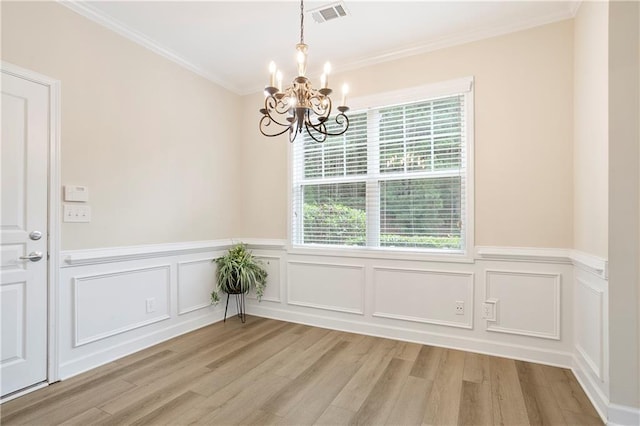 4130 Stonecypher Rd, Suwanee, GA 30024 - unfurnished dining area featuring a chandelier, light wood-type flooring, crown molding, wainscoting, and a decorative wall