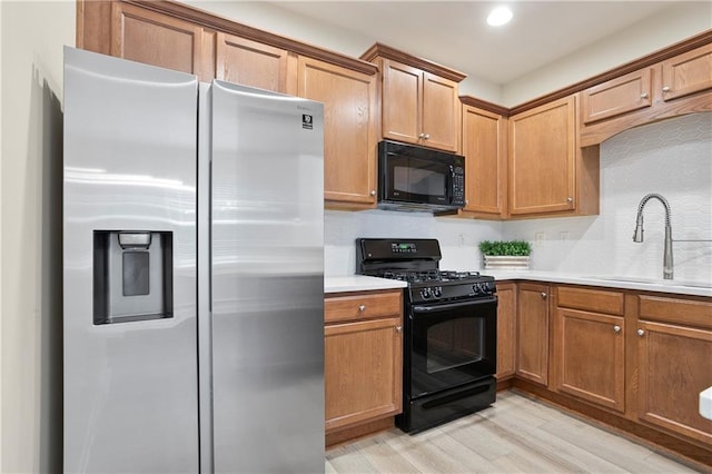 4130 Stonecypher Rd, Suwanee, GA 30024 - kitchen featuring black appliances, light wood-type flooring, light countertops, recessed lighting, and brown cabinetry