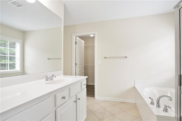 4130 Stonecypher Rd, Suwanee, GA 30024 - bathroom featuring vanity, a garden tub, tile patterned floors, and a walk in closet