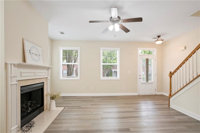 4130 Stonecypher Rd, Suwanee, GA 30024 - unfurnished living room featuring stairway, a high end fireplace, light wood-style flooring, and ceiling fan