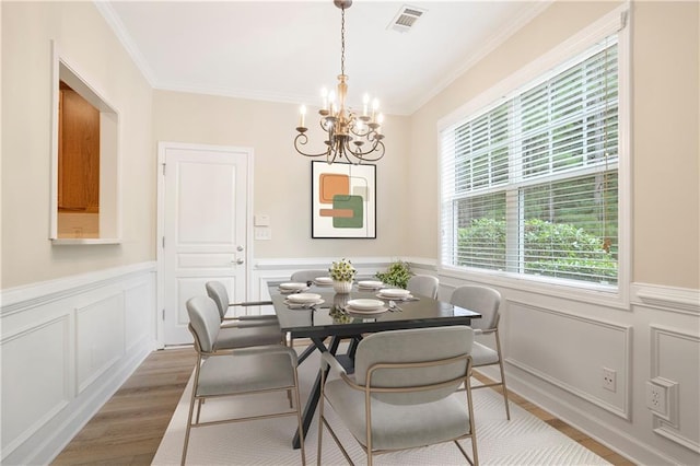 4130 Stonecypher Rd, Suwanee, GA 30024 - dining space with wood finished floors, crown molding, a chandelier, a wainscoted wall, and a decorative wall