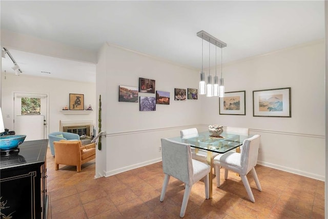 5180 Chemin De Vie, Atlanta, GA 30342 - dining space with baseboards, a glass covered fireplace, track lighting, and ornamental molding