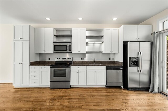 kitchen featuring dark brown cabinetry, sink, wood-type flooring, and stainless steel appliances