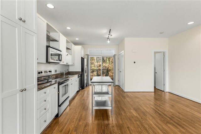 kitchen featuring stainless steel appliances, wood-type flooring, sink, and dark brown cabinetry