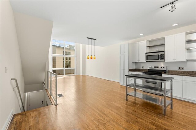 kitchen with hardwood / wood-style flooring, a healthy amount of sunlight, appliances with stainless steel finishes, and dark brown cabinets