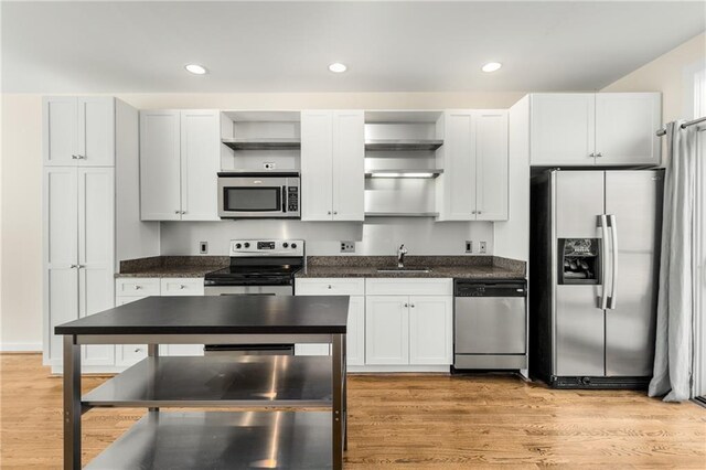 kitchen with stainless steel appliances, hanging light fixtures, dark brown cabinets, and dark hardwood / wood-style flooring