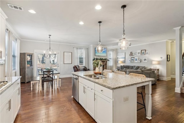 kitchen with white cabinetry, stainless steel dishwasher, sink, and an island with sink