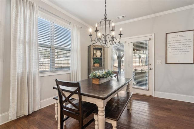 dining room with dark wood-type flooring, ornamental molding, and a notable chandelier