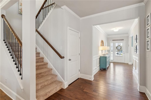 foyer entrance with crown molding and dark wood-type flooring