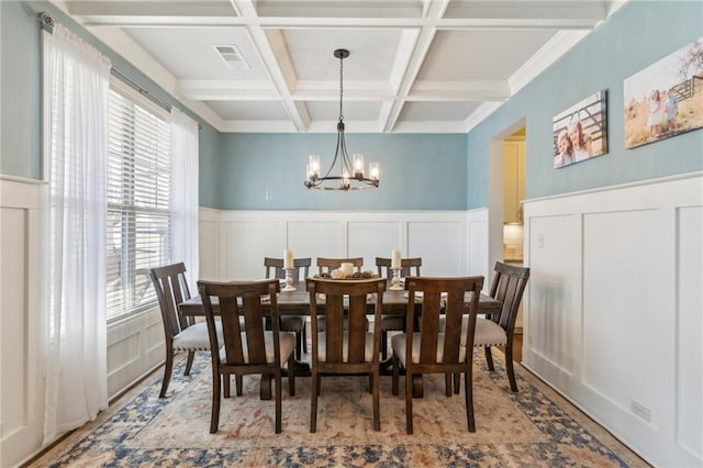 dining space with coffered ceiling, a notable chandelier, beam ceiling, and light wood-type flooring