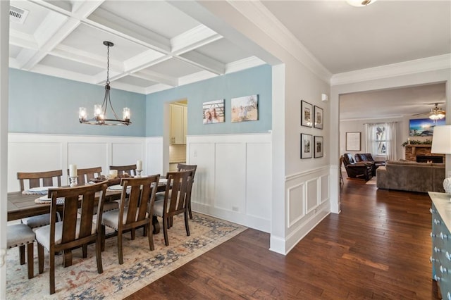 dining area featuring crown molding, dark wood-type flooring, an inviting chandelier, beam ceiling, and coffered ceiling