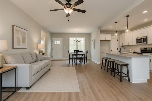573 Coach Bobby Dodd Rd, Dallas, GA 30132 - living area featuring recessed lighting, light wood-type flooring, baseboards, a chandelier, and a ceiling fan
