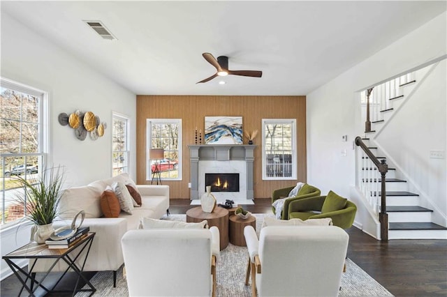 living room featuring visible vents, stairway, dark wood-type flooring, a high end fireplace, and baseboards