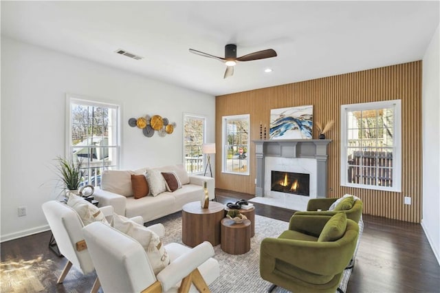 living room with visible vents, plenty of natural light, a premium fireplace, and wood finished floors