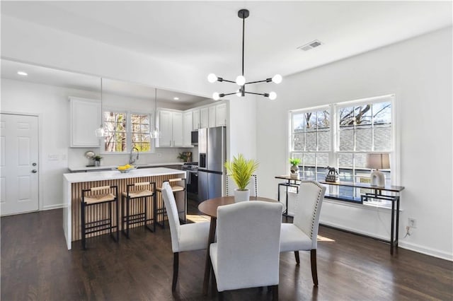 dining area featuring a chandelier, recessed lighting, dark wood-type flooring, visible vents, and baseboards