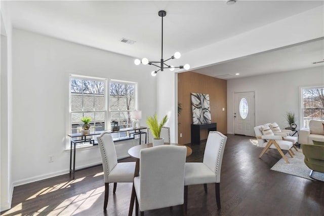 dining room with baseboards, visible vents, a chandelier, and dark wood-style flooring