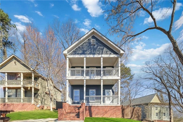 view of front facade with covered porch, a front yard, and a balcony