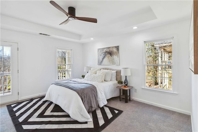 bedroom with baseboards, visible vents, a raised ceiling, and recessed lighting