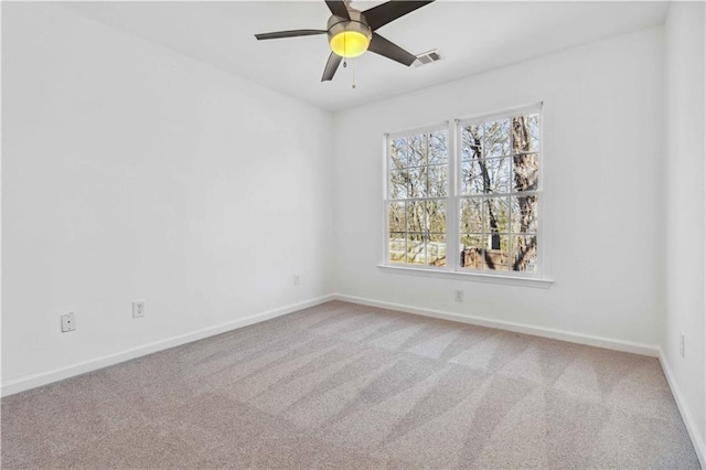 unfurnished room featuring ceiling fan, carpet, visible vents, and baseboards