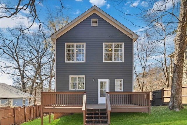 back of property featuring a fenced backyard, a deck, and a lawn