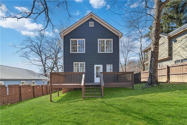 back of property with a fenced backyard, a yard, and a wooden deck